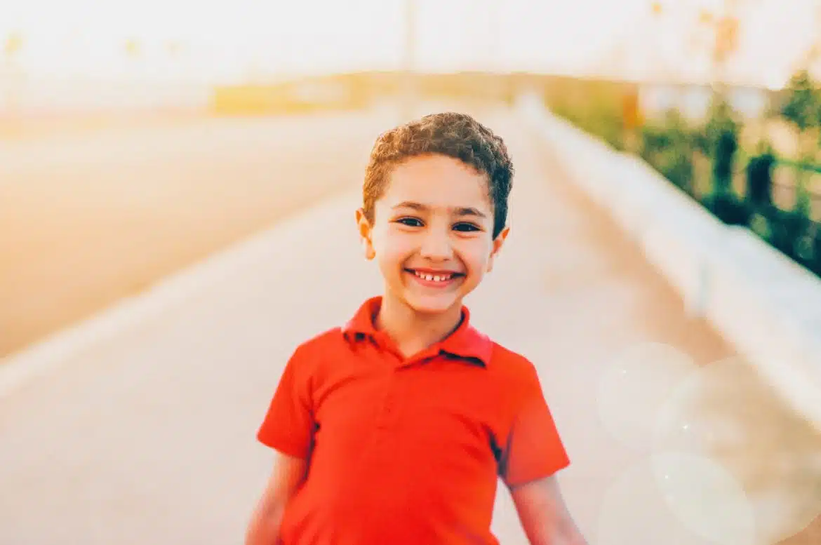 smiling boy wearing red polo shirt